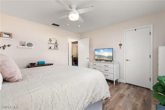 bedroom with ceiling fan, light hardwood / wood-style floors, and a textured ceiling