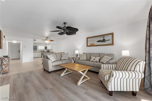 living room featuring ceiling fan and light hardwood / wood-style flooring