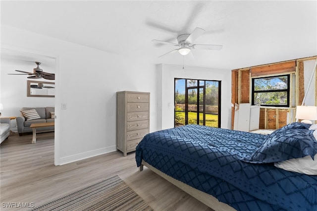 bedroom featuring access to exterior, ceiling fan, and light wood-type flooring