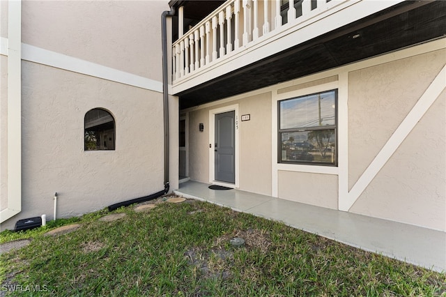 view of exterior entry featuring a balcony