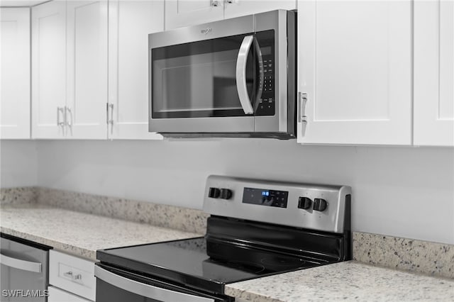 kitchen featuring light stone counters, white cabinets, and appliances with stainless steel finishes