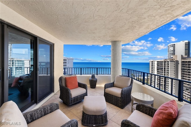 balcony with an outdoor living space and a water view