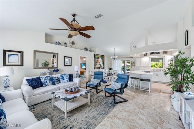 living room with ceiling fan with notable chandelier, high vaulted ceiling, and sink