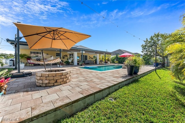 view of swimming pool with a patio, a yard, and an outdoor fire pit