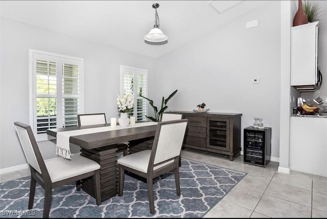 tiled dining area with lofted ceiling and beverage cooler