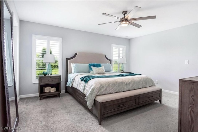 bedroom featuring multiple windows, light colored carpet, and ceiling fan