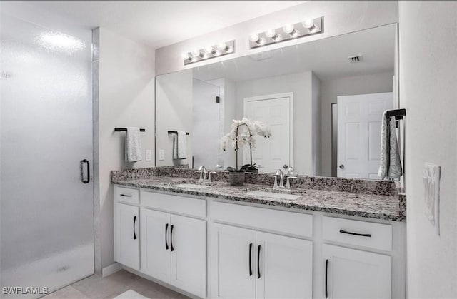 bathroom featuring tile patterned flooring, vanity, and walk in shower