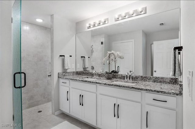 bathroom featuring vanity, a shower with shower door, and tile patterned floors