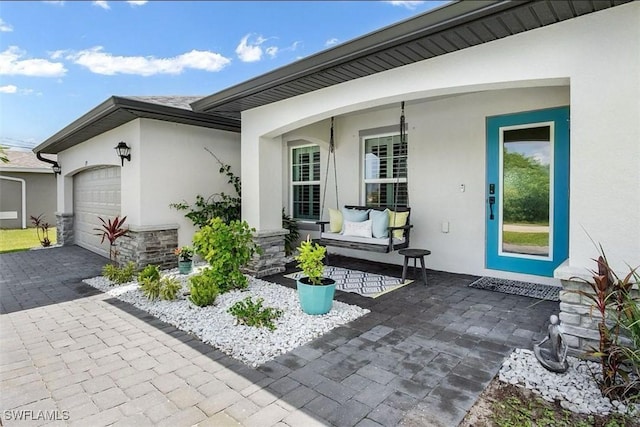 entrance to property with a garage and a porch