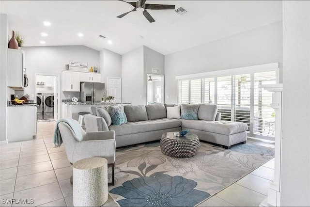 living room with ceiling fan, independent washer and dryer, high vaulted ceiling, and light tile patterned floors