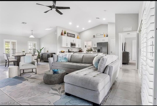 living room featuring light tile patterned floors, high vaulted ceiling, and ceiling fan