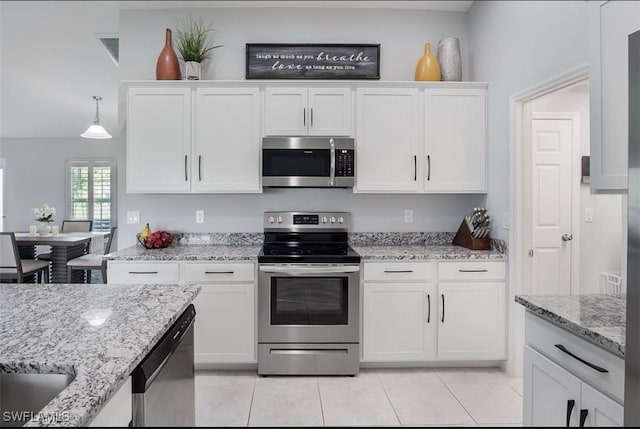 kitchen featuring pendant lighting, appliances with stainless steel finishes, light tile patterned floors, and white cabinets