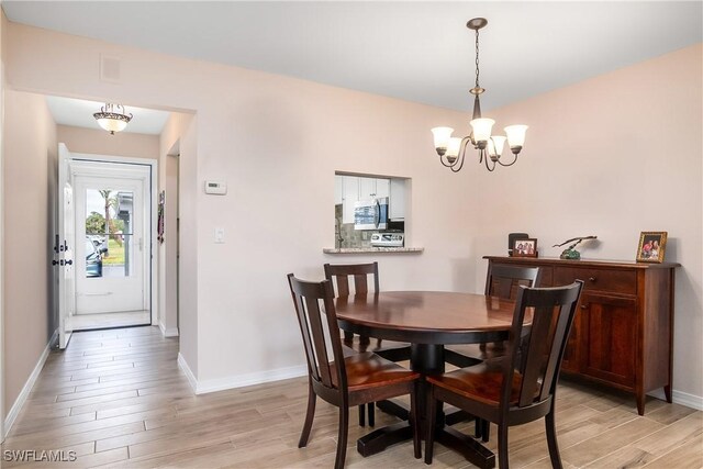 dining room with a chandelier and light wood-type flooring