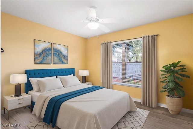 bedroom featuring light wood-type flooring, ceiling fan, and baseboards