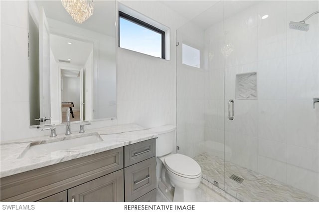 bathroom featuring toilet, a shower stall, a chandelier, and vanity