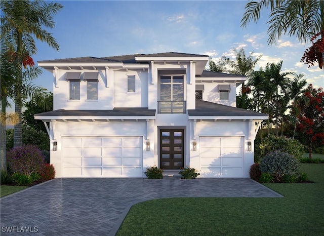 view of front of house featuring an attached garage, a front lawn, decorative driveway, and stucco siding