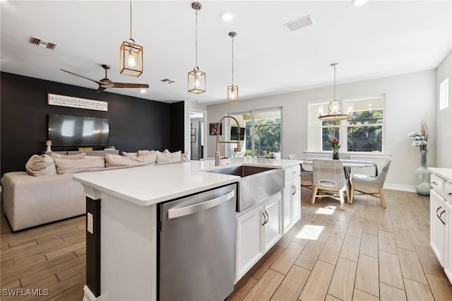 kitchen featuring pendant lighting, sink, a kitchen island with sink, white cabinetry, and stainless steel dishwasher