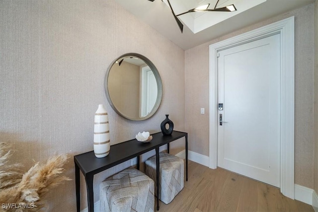 foyer featuring a skylight and light hardwood / wood-style floors