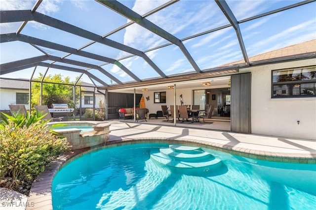 view of pool with an in ground hot tub, glass enclosure, and a patio area