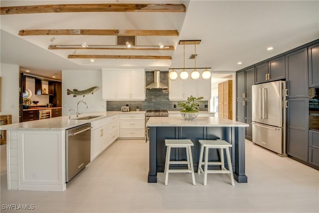 kitchen featuring sink, white cabinets, kitchen peninsula, stainless steel appliances, and wall chimney exhaust hood