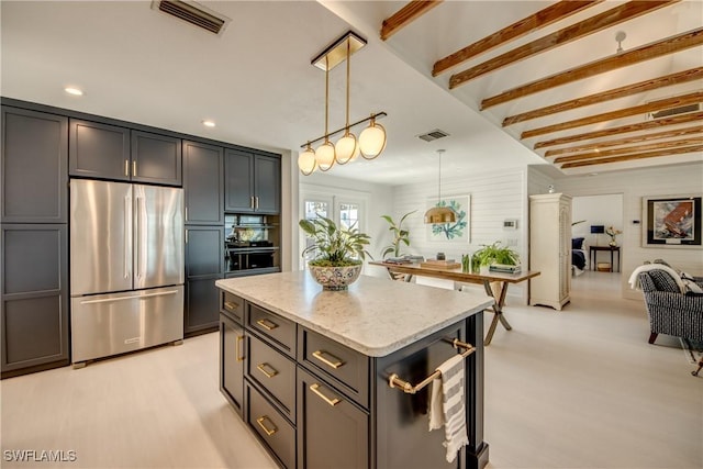 kitchen with a kitchen island, beamed ceiling, stainless steel fridge, hanging light fixtures, and light stone countertops