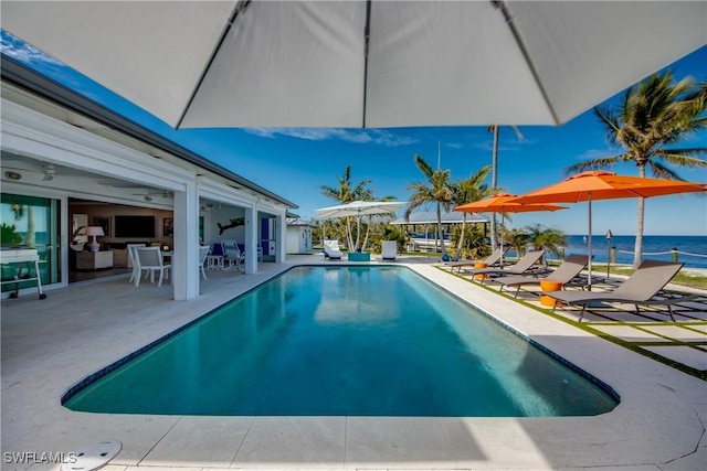 view of swimming pool with a water view and a patio