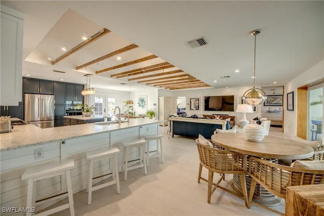 dining space with sink and beamed ceiling