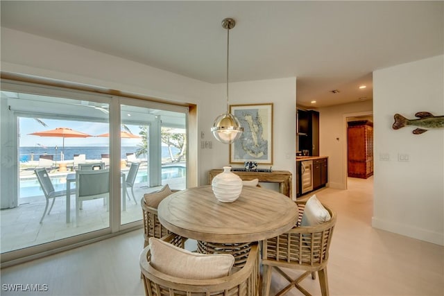 dining area featuring a water view and wine cooler