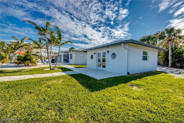 rear view of property featuring a yard and french doors