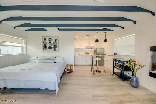 bedroom featuring vaulted ceiling with beams, sink, and wood walls