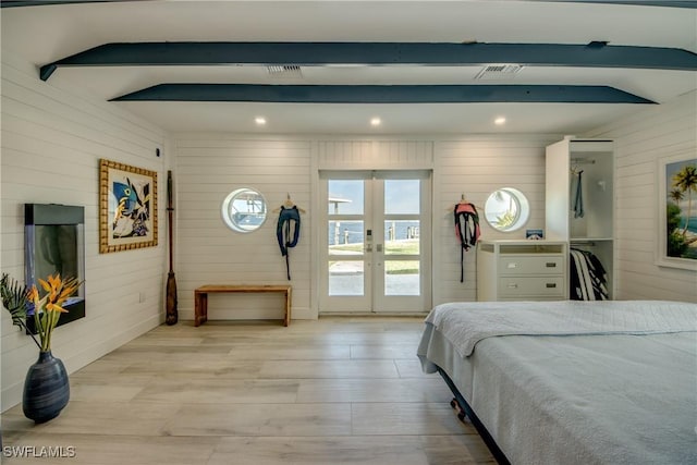 bedroom with access to exterior, vaulted ceiling with beams, wood walls, french doors, and light wood-type flooring