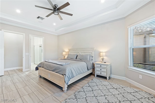 bedroom with ceiling fan, ornamental molding, a tray ceiling, and multiple windows