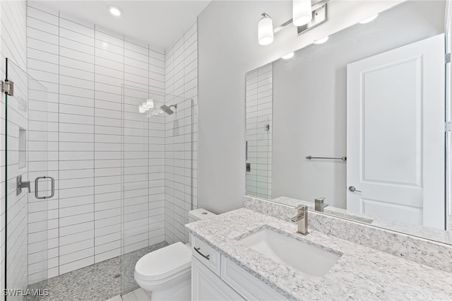 bathroom with walk in shower, vanity, and toilet