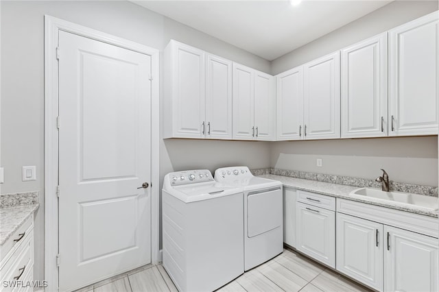 laundry area featuring cabinets, sink, and washing machine and dryer