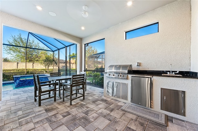 view of patio / terrace featuring a grill, a lanai, exterior kitchen, and sink