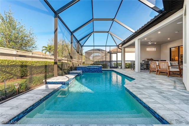 view of pool featuring a lanai, a patio, pool water feature, and an in ground hot tub