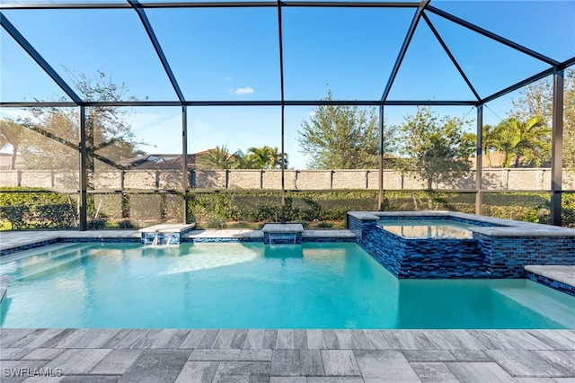 view of pool featuring an in ground hot tub, pool water feature, and glass enclosure