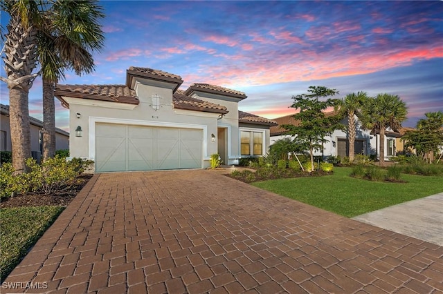 mediterranean / spanish house featuring a yard and a garage