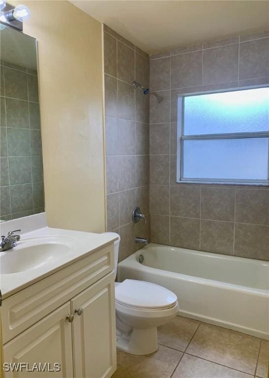 full bathroom featuring tiled shower / bath, vanity, toilet, and tile patterned flooring