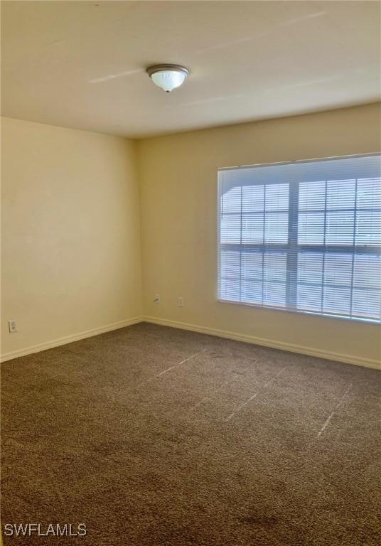 empty room with dark colored carpet