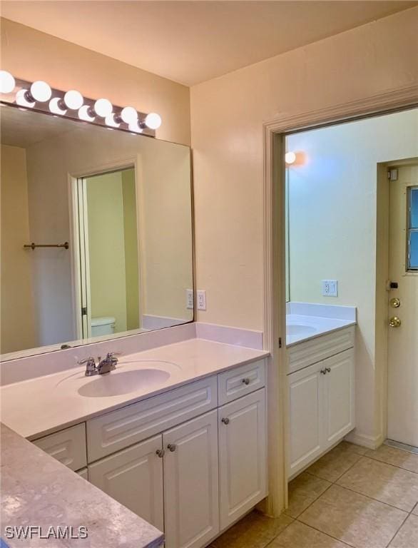 bathroom featuring tile patterned floors, toilet, and vanity