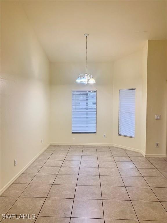 unfurnished room with light tile patterned floors and a chandelier