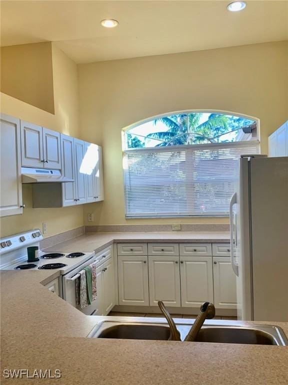 kitchen with sink, white appliances, and white cabinets