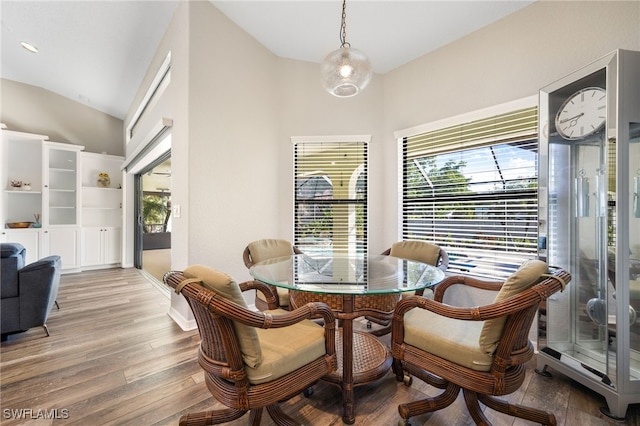 dining room with vaulted ceiling and hardwood / wood-style floors