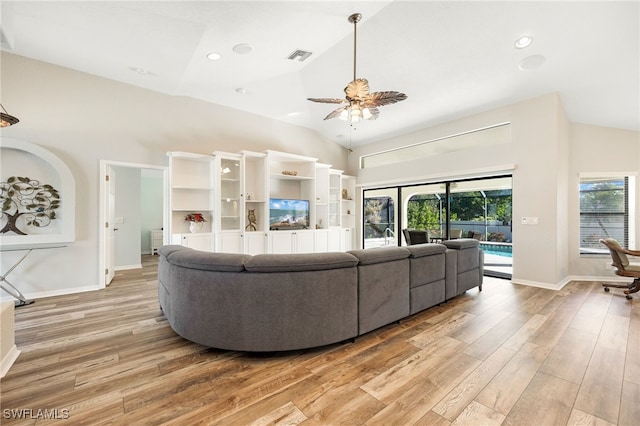 living room with ceiling fan, lofted ceiling, and light wood-type flooring