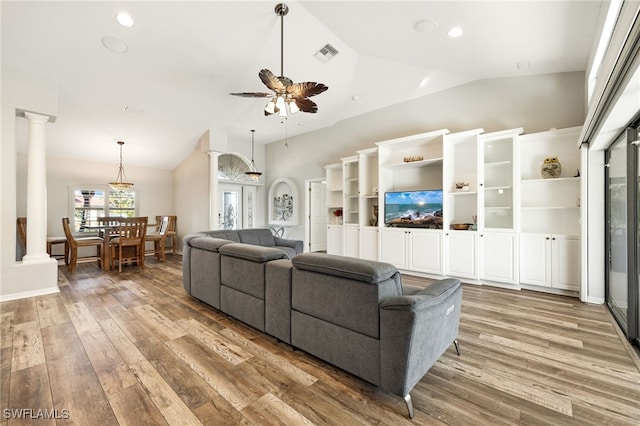 living room featuring ornate columns, lofted ceiling, hardwood / wood-style floors, and ceiling fan