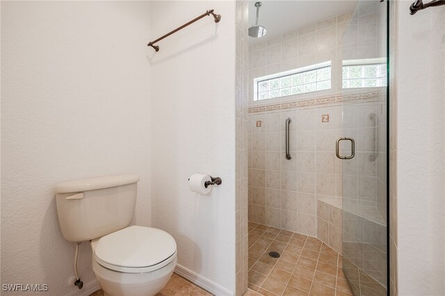 bathroom with a shower with shower door and toilet