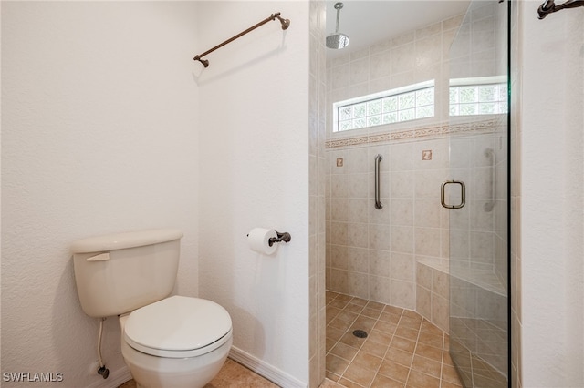 full bath with baseboards, a shower stall, and toilet