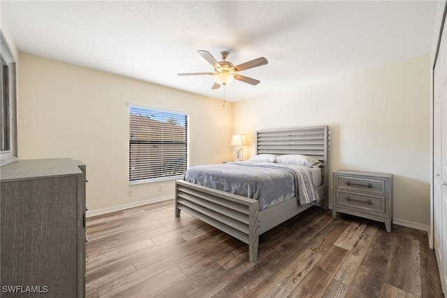 bedroom with ceiling fan, baseboards, and wood finished floors