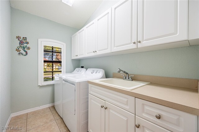 washroom featuring cabinets, washing machine and dryer, sink, and light tile patterned floors